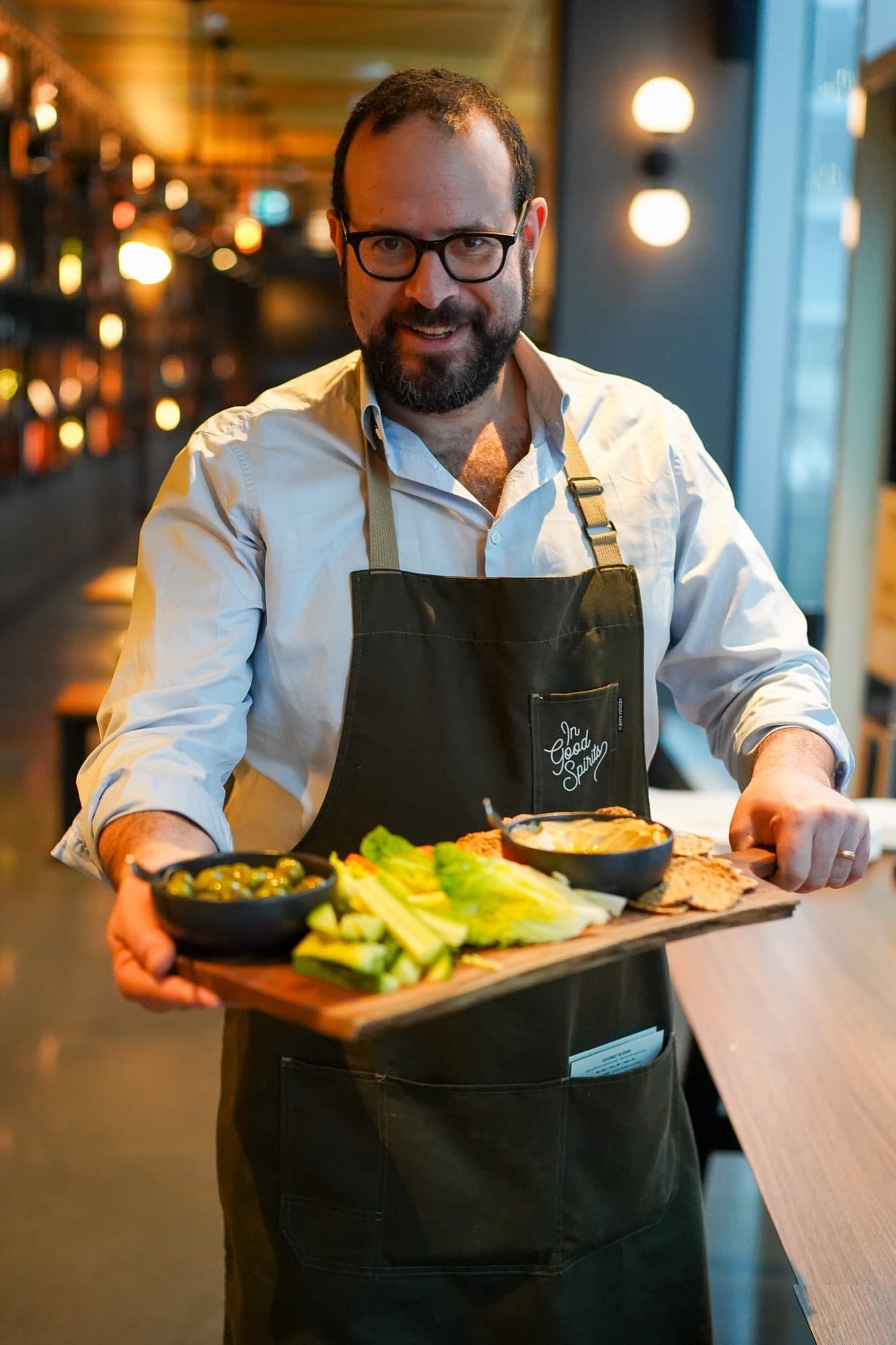 Oliver Stern of In Good Spirits carrying a sharing board