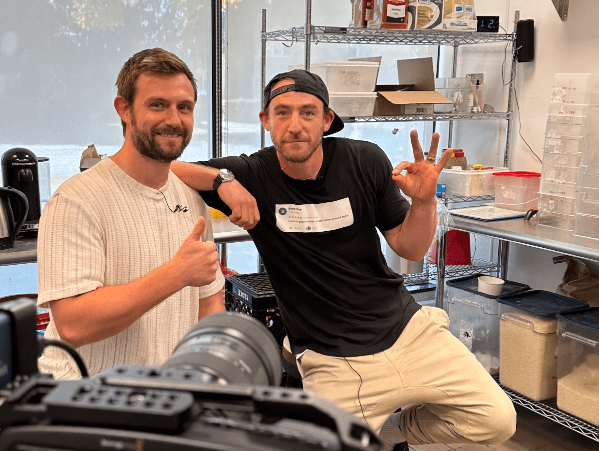 Kyle Guilfoyle and Gabe, owner of Chef on Call, in a restaurant prep kitchen with a camera rolling